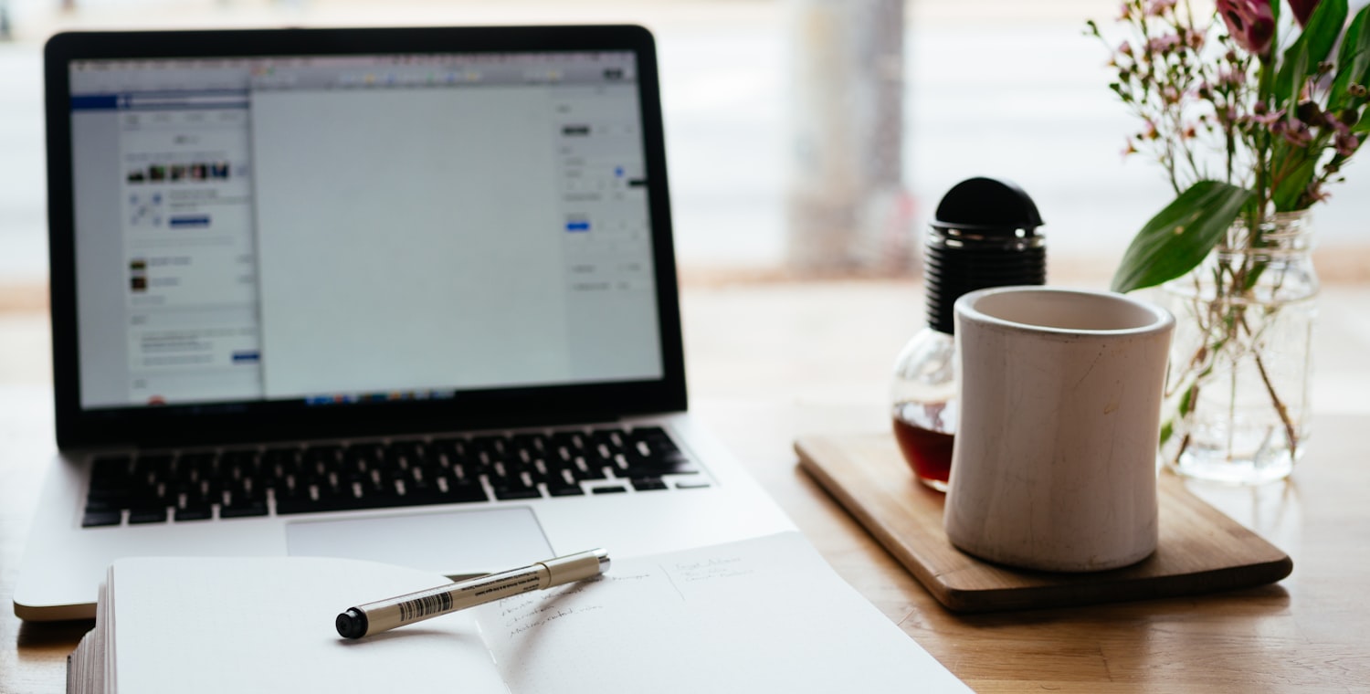 Ordinateur portable, carnet et café sur un bureau